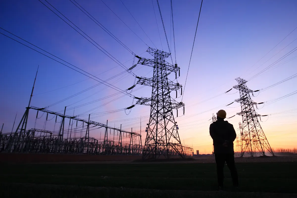 Aging infrastructure Utility worker inspecting lines at dusk